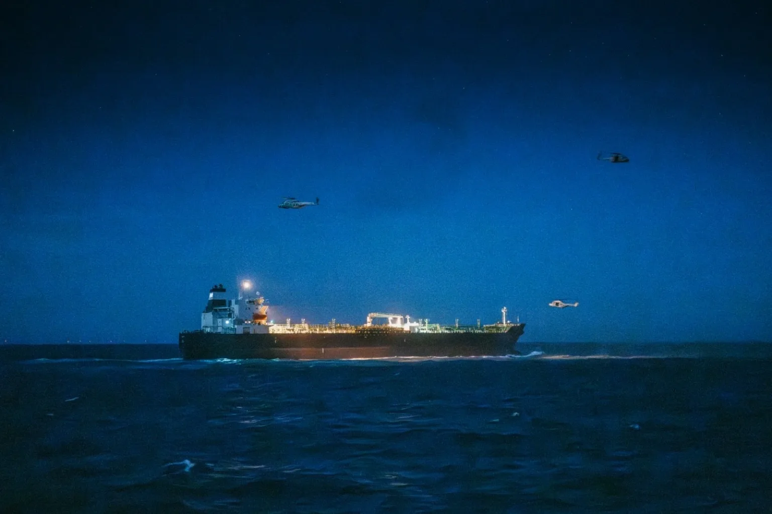 Petrolier în noapte, escortat de elicoptere în Marea Nordului.