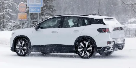 Două modele Volkswagen pe drum, unul electric și unul hibrid.