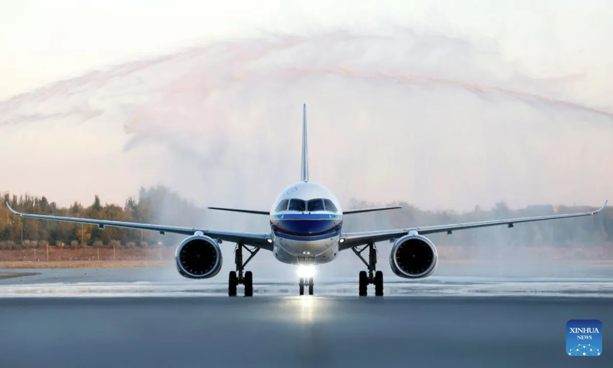 Avionul C919 aterizând pe aeroportul din Yinchuan, sub un arc de apă.
