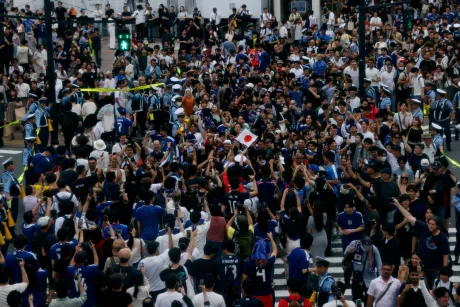 Suporteri japonezi sărbătoresc victoria la Shibuya Crossing, plini de entuziasm.