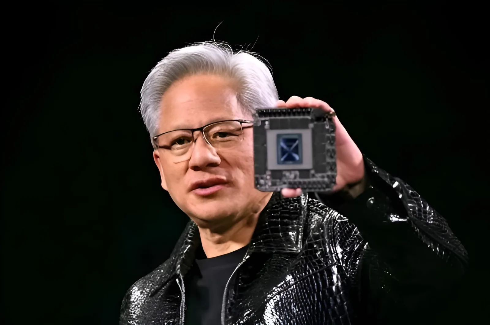 Jensen Huang prezentând un procesor NVIDIA într-o conferință tehnologică.