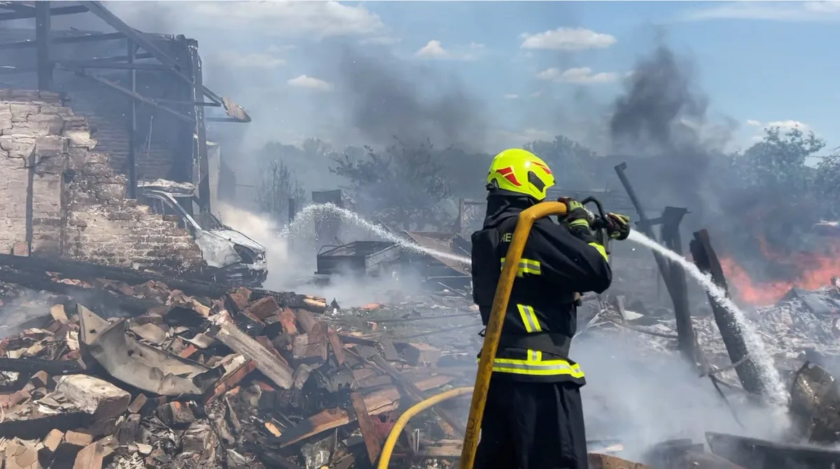 Pompier stropind cu apă dărâmăturile unei clădiri distruse în urma atacurilor aeriene.