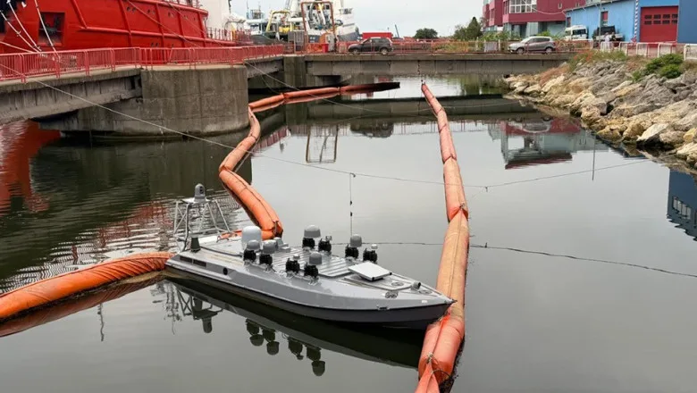 Dronă navală ancorată în Portul Constanța, înconjurată de bariere de protecție.