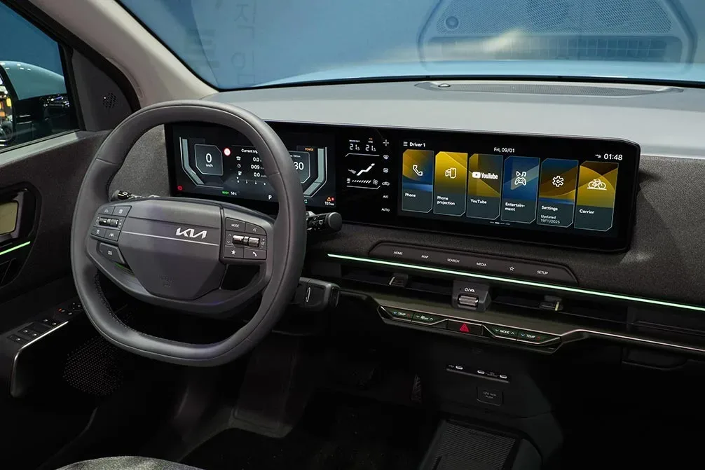 Interiorul modern al Kia EV2, cu ecrane mari și comenzi fizice.