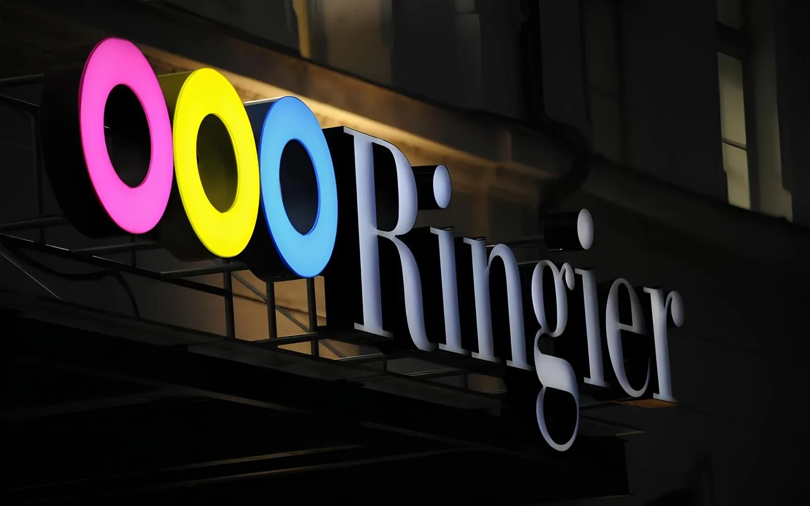 Logo colorat Ringier pe un fundal întunecat, simbolizând inovația.