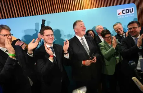Susținători ai CDU aplaudă la un eveniment electoral.