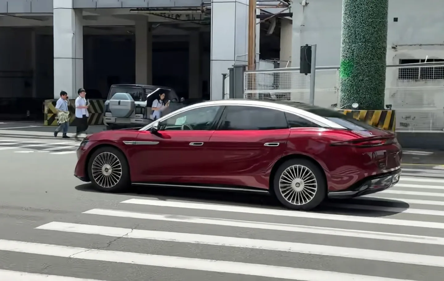 Sedanul Da Han în culori roșu-argintiu pe stradă, evidențiind designul său elegant.