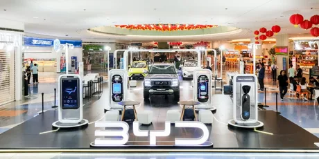 Expoziție BYD cu vehicule electrice și stații de încărcare moderne.
