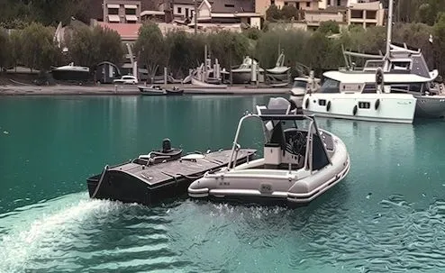 Vapor de patrulare navigând pe apă, în apropierea unui port.