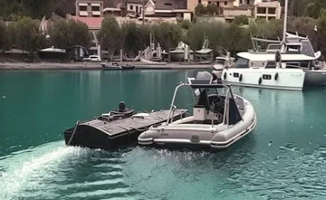 Vapor de patrulare navigând pe apă, în apropierea unui port.