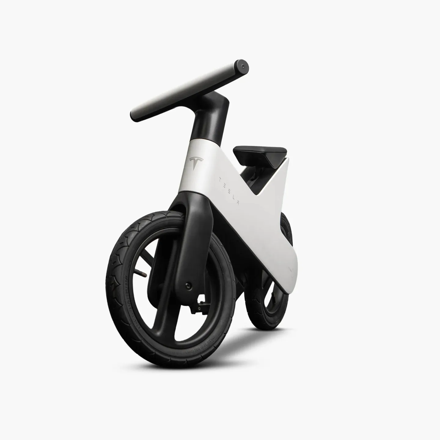 Bicicletă de echilibru Tesla pentru copii, design minimalist alb-negru.