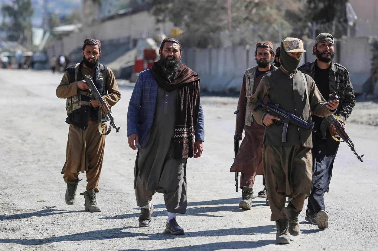Membri ai talibanilor patrulează pe străzile din Afganistan, purtând arme.