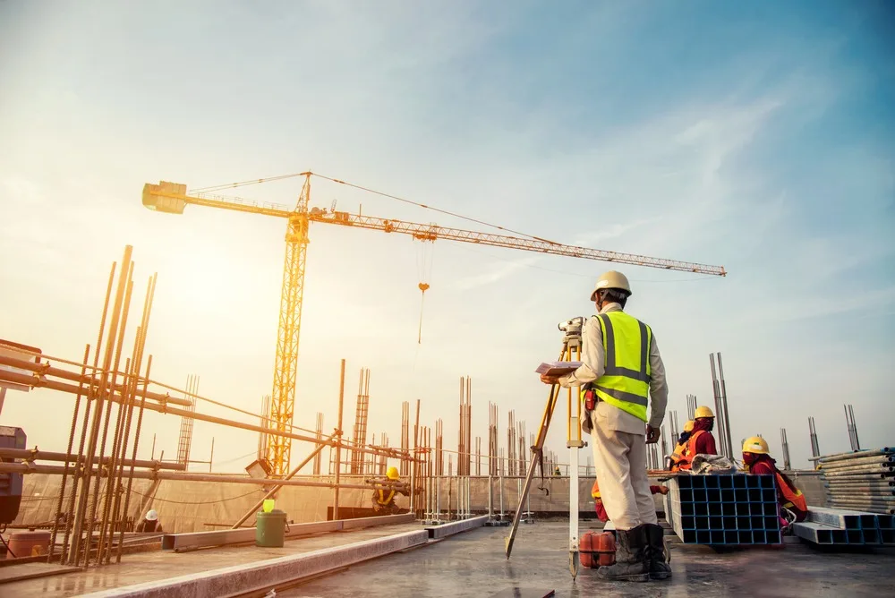 Lucrări de construcţii în plină desfăşurare, cu muncitori pe şantier.