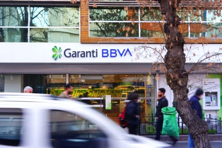 Sediul Garanti BBVA, cu clienți și mașini în mișcare.
