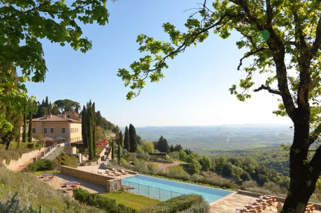 Peisaj idilic din Toscana, cu hotelul Castiglion del Bosco și piscine în natură.