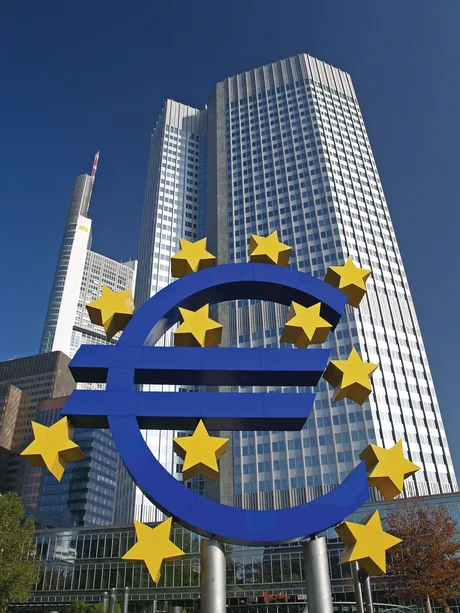 Simbolul euro în fața unei clădiri moderne din Europa.