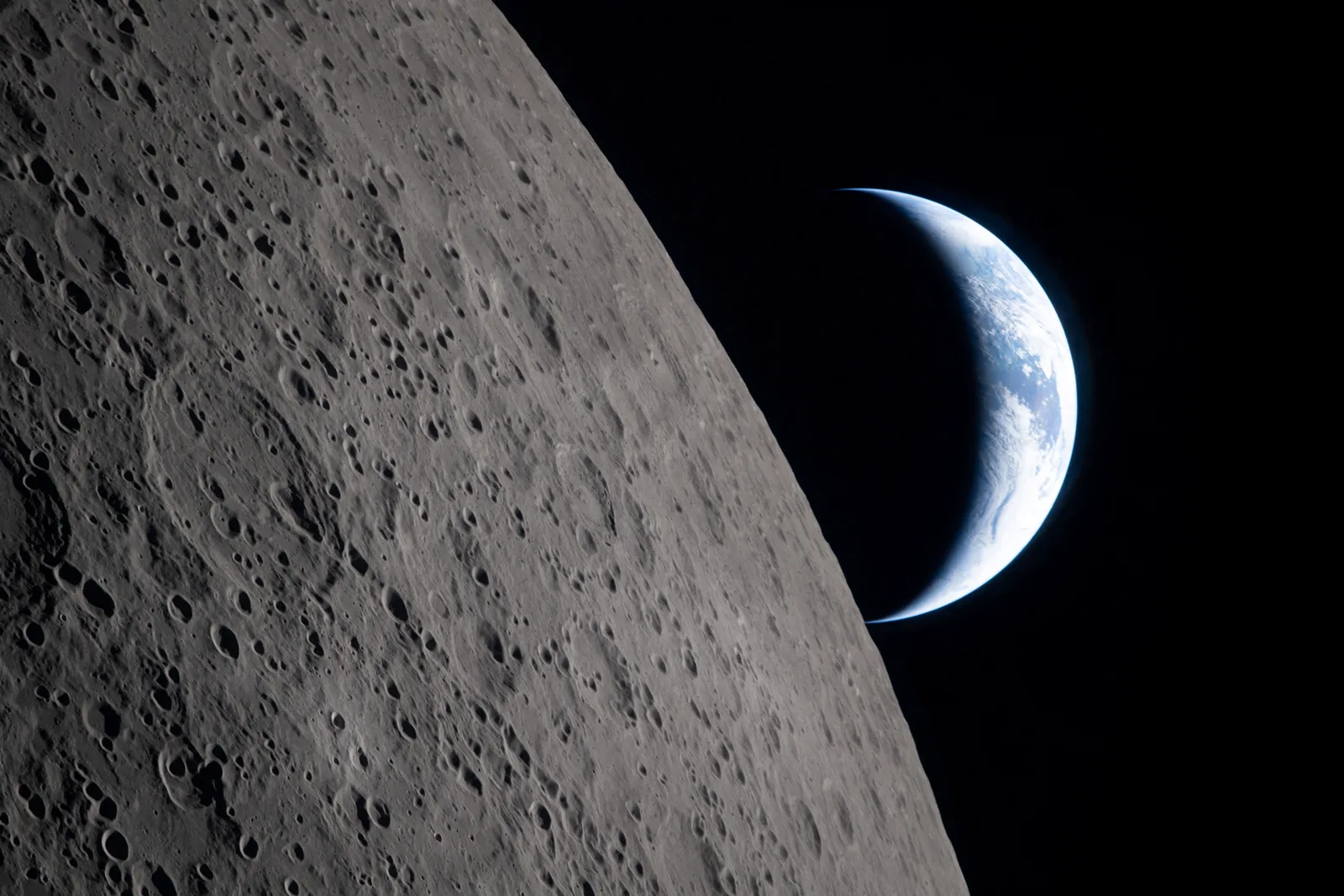 Luna văzută de pe orbită, cu Pământul în fundal, evidențiind craterele lunare.