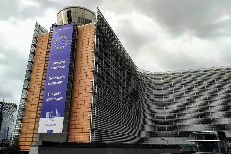 Clădirea Comisiei Europene cu un banner informativ pe fațadă.