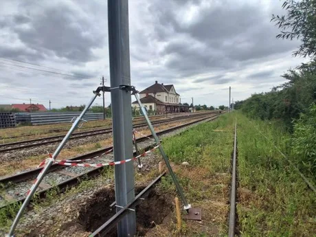 Lucrări de electrificare pe linia ferată Dărmănești–Vicșani, cu stâlpi metalici montați.