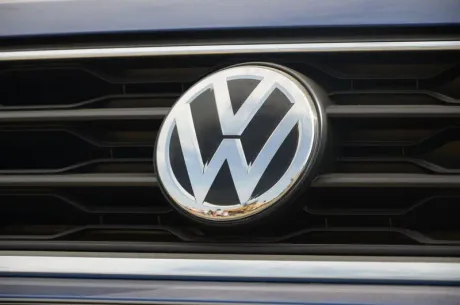 Sigla Volkswagen pe grila unui automobil, simbol al industriei auto.