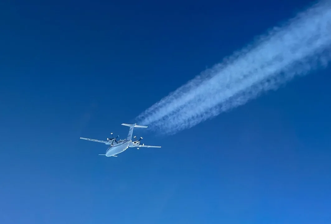 Avion privat german zburând deasupra Italiei, cu urme de condens în urma sa.