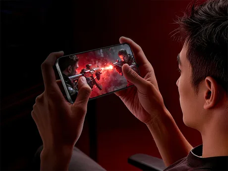 Utilizator jucând un joc pe telefonul Redmi K90 Max, cu un ecran vibrant.