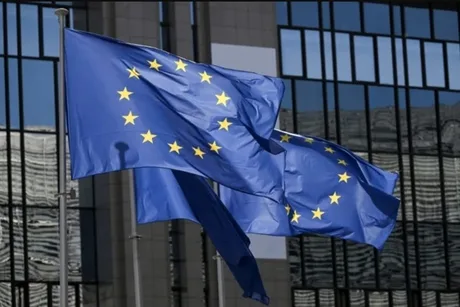 Steagurile Uniunii Europene fluturând în fața clădirii instituțiilor europene.