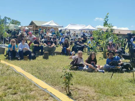 Public numeros la festival, bucurându-se de muzică și atmosferă plăcută în natură.