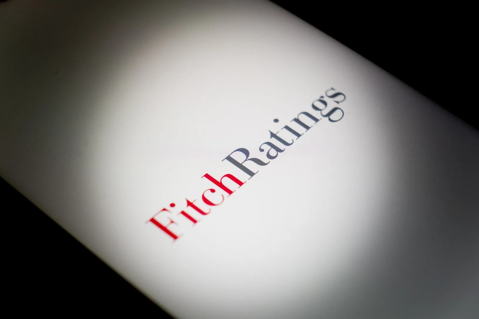 Logo-ul agenției Fitch pe un fundal alb, simbolizând evaluarea financiară.