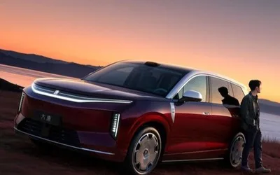 Un vehicul electric modern parcat pe malul unei ape la apus.
