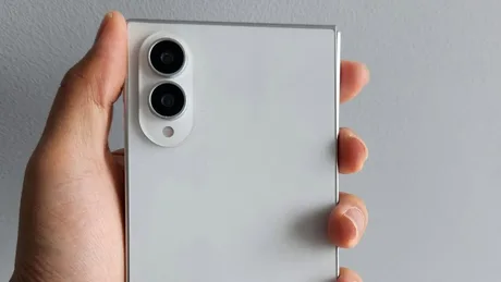Un telefon pliabil în mână, cu două camere vizibile pe spate.