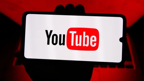Ecran de televizor cu logo-ul YouTube pe fundal colorat.