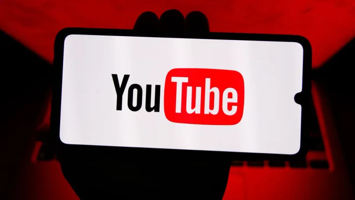 Ecran de televizor cu logo-ul YouTube pe fundal colorat.