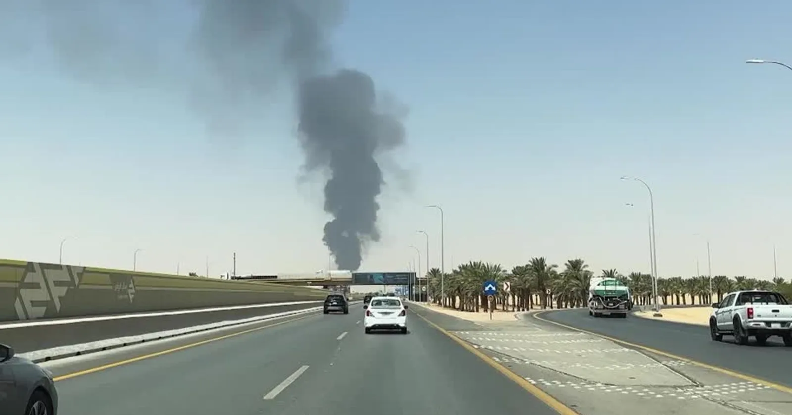 Fum negru ridicându-se deasupra unei zone urbane din Arabia Saudită.