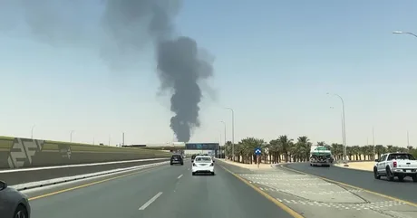 Fum negru ridicându-se deasupra unei zone urbane din Arabia Saudită.