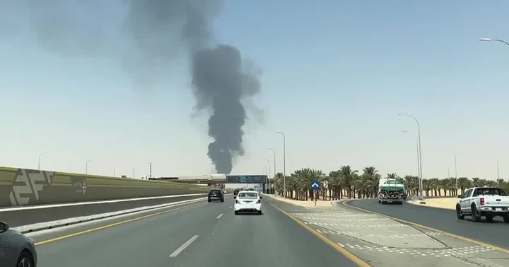 Fum negru ridicându-se deasupra unei zone urbane din Arabia Saudită.