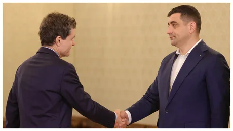 George Simion și Nicușor Dan se salută într-un cadru formal.