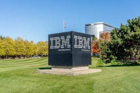 Sediul IBM într-un peisaj verde, cu arbori și cer senin.