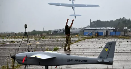 Un operator lansează o dronă pe un teren de zbor în Polonia.