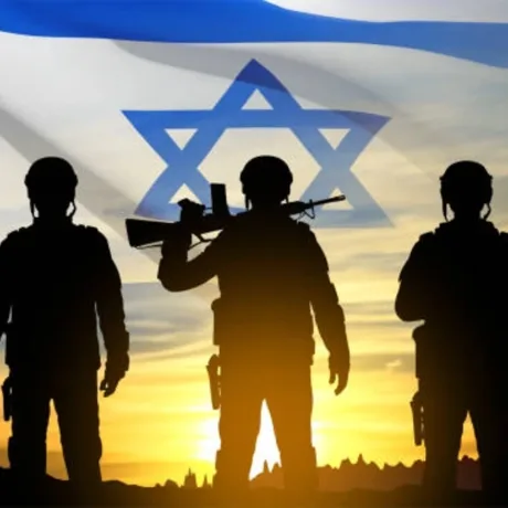 Soldați israelieni în fața steagului național, pregătiți pentru acțiune.