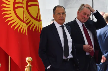 Serghei Lavrov și un oficial în fața drapelului Kârgâzstanului.
