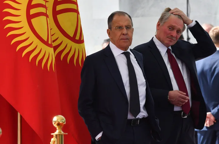 Serghei Lavrov și un oficial în fața drapelului Kârgâzstanului.