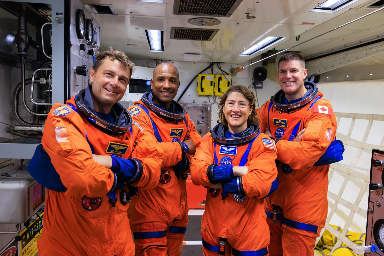 Cei patru astronauți ai misiunii Artemis II în costume de zbor.