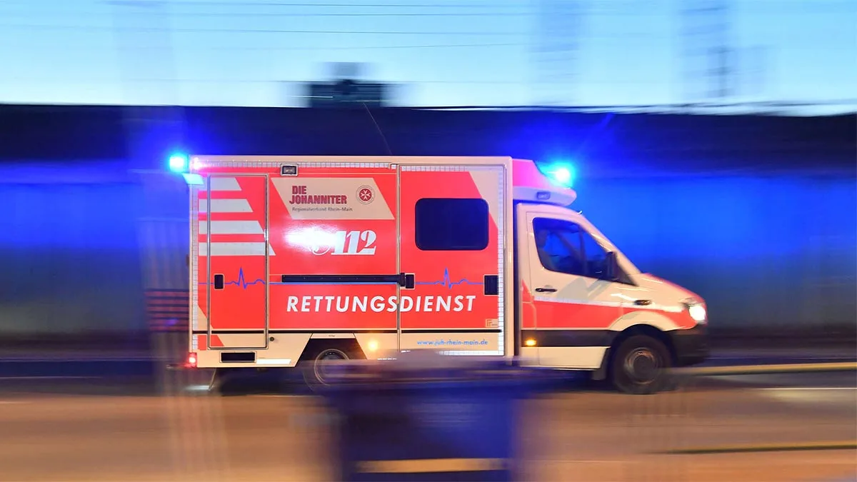Ambulanță în misiune, cu girofarul activat, pe un drum din Germania.