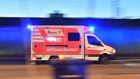 Ambulanță în misiune, cu girofarul activat, pe un drum din Germania.