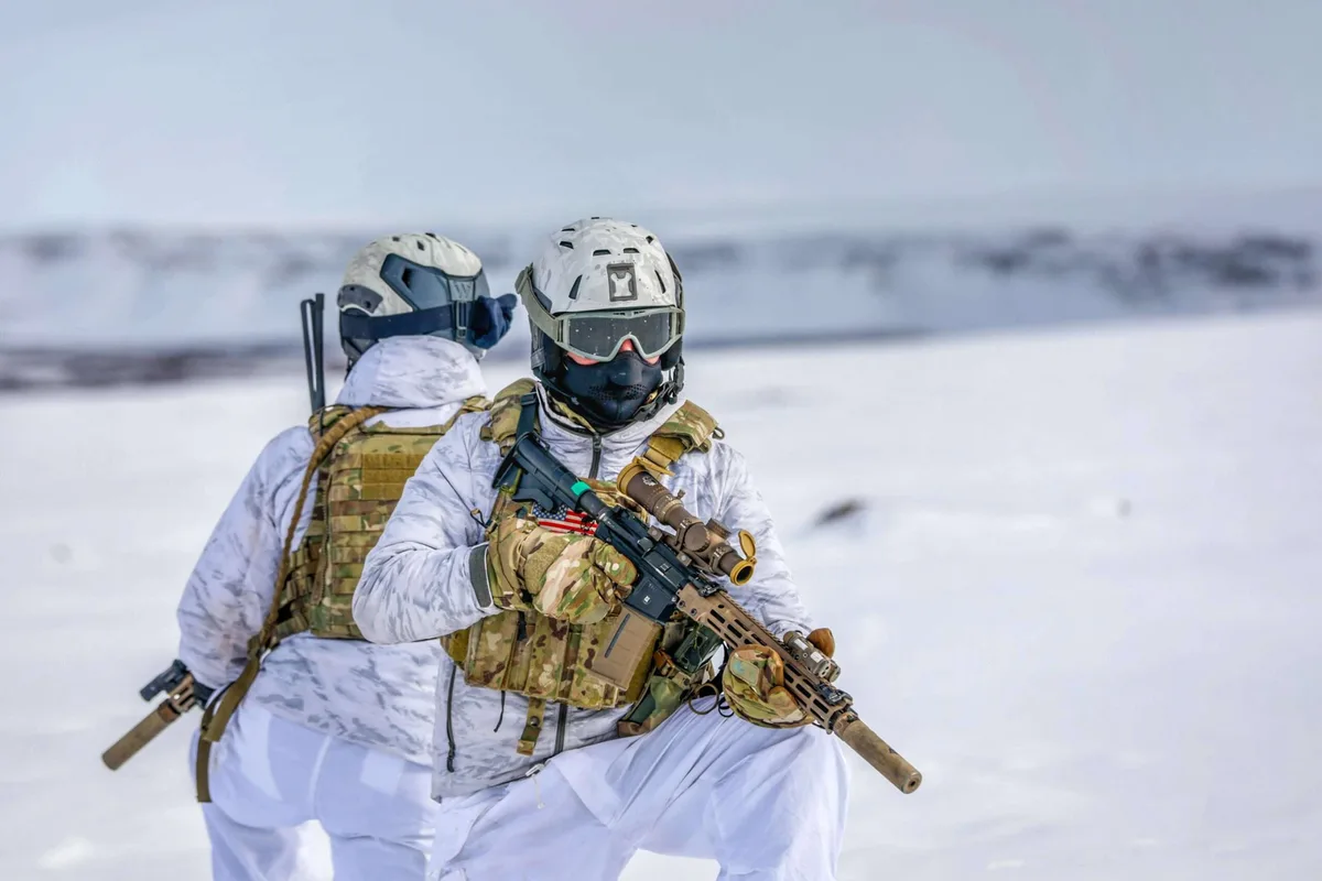 Soldați în echipament de iarnă în peisaj arctic.