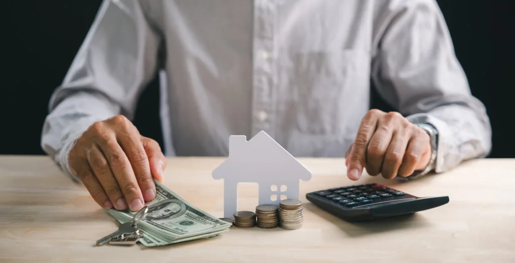 Persoană analizând costurile locuinței și opțiunile financiare.