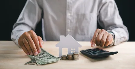 Persoană analizând costurile locuinței și opțiunile financiare.