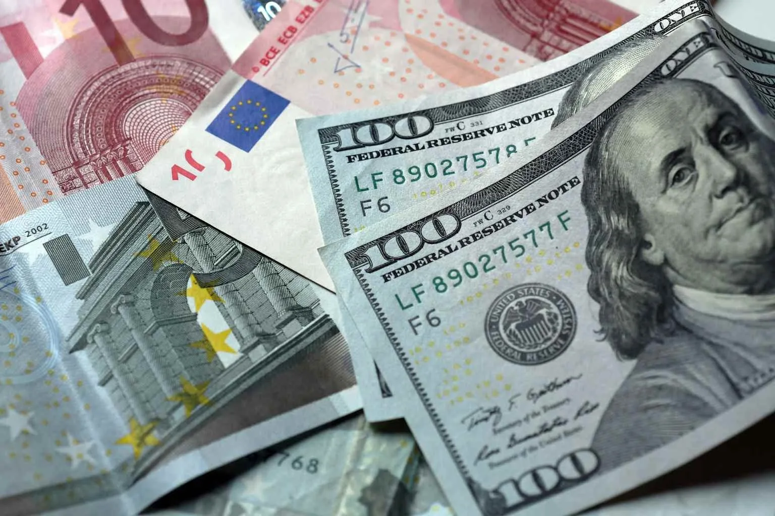Euro și dolari americani pe un fundal de bancnote diverse.