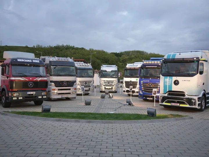 Camioane Mercedes-Benz expuse într-o zonă de prezentare, evidențiind diversitatea modelelor.